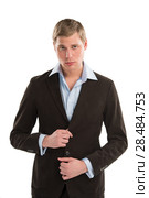 Portrait of a confident young male executive buttoning his cuff on white background. Стоковое фото, фотограф Kirill Kedrinskiy / Ingram Publishing / Фотобанк Лори