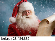 Portrait of happy Santa Claus reading Christmas letter outdoors at north pole at snowfall. Стоковое фото, фотограф Kirill Kedrinskiy / Ingram Publishing / Фотобанк Лори