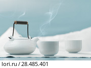 Teapot and cups on table at comfortable relaxation lounge. Стоковое фото, фотограф Kirill Kedrinskiy / Ingram Publishing / Фотобанк Лори