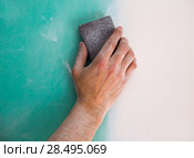 Plastering man hand sanding the plaste in drywall seam plasterboard. Стоковое фото, фотограф Tono Balaguer / Ingram Publishing / Фотобанк Лори