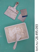 Platering tools for plaster like plaste trowel spatula on green drywall plasterboard. Стоковое фото, фотограф Tono Balaguer / Ingram Publishing / Фотобанк Лори