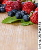 Strawberries raspberries and blueberries on the wooden table macro. Стоковое фото, фотограф Olena Mykhaylova / Ingram Publishing / Фотобанк Лори