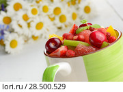 Green ceramic cup with mixed fruit salad on the white table. Стоковое фото, фотограф Olena Mykhaylova / Ingram Publishing / Фотобанк Лори