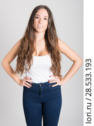 Portrait of young woman with long hair wearing white t-shirt and blue jeans on white background. Стоковое фото, фотограф Javier Sánchez Mingorance / Ingram Publishing / Фотобанк Лори