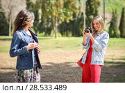 Two young tourist women taking photographs outdoors. Стоковое фото, фотограф Javier Sánchez Mingorance / Ingram Publishing / Фотобанк Лори
