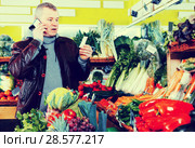Man specifying shopping list in store. Стоковое фото, фотограф Яков Филимонов / Фотобанк Лори