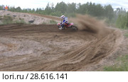 June 10, 2018 Russian Federation, Bryansk region, Ivot - Extreme sports, cross motocross. The motorcyclist enters the turn on the race track. Dirt is flying from under the wheels. The machine overcomes obstacles. Athletes fly through the air. slow motion. Редакционное видео, видеограф Константин Мерцалов / Фотобанк Лори