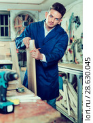 Man measuring boards for furniture at workshop. Стоковое фото, фотограф Яков Филимонов / Фотобанк Лори