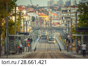 View of the city of Porto with the arch Dom Luis I bridge and two metro trams. At dawn. Color toning. Редакционное фото, фотограф Сергей Цепек / Фотобанк Лори