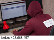 Интернет тролль у компьютера. Мужчина с надписью на спине : "Don't feed the troll" (Не кормите тролля) пишет гадости на форуме. Стоковое фото, фотограф Лариса Капусткина / Фотобанк Лори