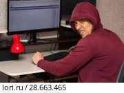 Интернет тролль у компьютера. Неприятный молодой человек пишет гадости на форуме. Стоковое фото, фотограф Лариса Капусткина / Фотобанк Лори