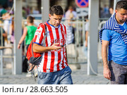 Чемпионат мира по футболу FIFA 2018 года. Футбольный болельщик в полосатой бело-красной футболке на Красной площади. Москва. Редакционное фото, фотограф Алёшина Оксана / Фотобанк Лори