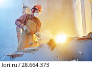 worker with sledgehammer at indoor wall destroying. Стоковое фото, фотограф Дмитрий Калиновский / Фотобанк Лори