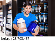 Athletic man seller demostration sport nutrition products in shop. Стоковое фото, фотограф Яков Филимонов / Фотобанк Лори