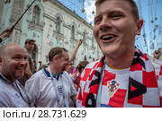 Болельщики национальной футбольной сборной Хорватии идут сквозь строй английских болельщиков по Никольской улице перед началом полуфинального матча Чемпионата мира по футболу FIFA 2018 между сборными командами Хорватии и Англии в городе Москве, Россия. Редакционное фото, фотограф Николай Винокуров / Фотобанк Лори