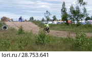 June 10, 2018 Russian Federation, Bryansk region, Ivot - Extreme sports, cross motocross. The motorcyclist enters the turn on the race track. Dirt is flying from under the wheels. The machine overcomes obstacles. Athletes fly through the air. slow motion. Редакционное видео, видеограф Константин Мерцалов / Фотобанк Лори