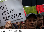 Участник митинга против повышения пенсионного возраста  и налогов держит плакат с надписью "Нет росту налогов" на территории Гайд-парка в парке Сокольники города Москвы, Россия (2018 год). Редакционное фото, фотограф Николай Винокуров / Фотобанк Лори