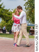 Russia, Samara, August 2017: a beautiful young couple dancing on the embankment of the Volga River on a summer hot day. Редакционное фото, фотограф Акиньшин Владимир / Фотобанк Лори