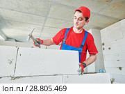 walling. bricklayer installing autoclaved aerated concrete blocks. Стоковое фото, фотограф Дмитрий Калиновский / Фотобанк Лори