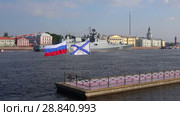 Развевающиеся Андреевский и российский флаги на фоне сторожевого фрегата "Адмирал Макаров". День ВМФ в Санкт-Петербурге (2018 год). Редакционное видео, видеограф Виктор Карасев / Фотобанк Лори