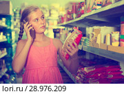 Young customer girl is advised by phone what pasta she should bu. Стоковое фото, фотограф Яков Филимонов / Фотобанк Лори