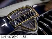 Крупным планом логотип автомобиля Aurus Senat российского люксового бренда Aurus, разработанных ФГУП "НАМИ" в рамках проекта "Кортеж", на Московском международном автомобильном салоне (ММАС – 2018) в МВЦ "Крокус Экспо", Россия. Редакционное фото, фотограф Николай Винокуров / Фотобанк Лори