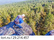 An elderly man sits on a rock high in the mountains in a prayer pose. Стоковое фото, фотограф Акиньшин Владимир / Фотобанк Лори