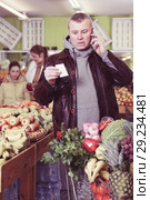 Man specifying shopping list in store. Стоковое фото, фотограф Яков Филимонов / Фотобанк Лори