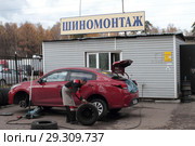 Рабочий шиномонтажа меняет колёса в Балашихе на улице Мира (2018 год). Редакционное фото, фотограф Дмитрий Неумоин / Фотобанк Лори