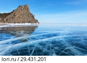 Lake Baikal. Beautiful winter landscape with transparent blue ice with cracks near the Big Bell Tower (Kolokolny Cape) Rock on a sunny frosty day. Стоковое фото, фотограф Виктория Катьянова / Фотобанк Лори