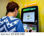 Оплата счетов за ЖКХ с помощью терминала (2018 год). Редакционное фото, фотограф Вячеслав Палес / Фотобанк Лори