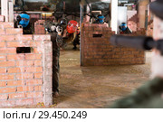 Players hide behind barricades on the battlefield in the paintball club. Стоковое фото, фотограф Яков Филимонов / Фотобанк Лори