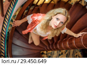 girl in silk robe stand on wooden spiral staircase. Стоковое фото, фотограф katalinks / Фотобанк Лори