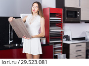 Young girl choosing material for fronts for kitchen. Стоковое фото, фотограф Яков Филимонов / Фотобанк Лори