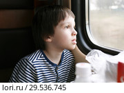 Lovely little boy looks out of window in the train. Стоковое фото, фотограф ivolodina / Фотобанк Лори