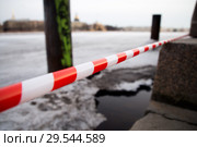 Ограничительная ленточка на спусках к реке Неве после вступившего в силу запрета выхода на лед (2018 год). Стоковое фото, фотограф Евгений Кашпирев / Фотобанк Лори