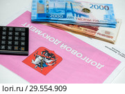 Долговой документ за коммунальные услуги, калькулятор и российские деньги. Оплата коммуналки (2018 год). Редакционное фото, фотограф Игорь Низов / Фотобанк Лори