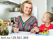Mother working and girl eating. Стоковое фото, фотограф Яков Филимонов / Фотобанк Лори
