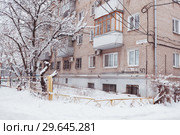 Corner of a multystoried house with the road and trees in the winter (2018 год). Редакционное фото, фотограф Владимир Арсентьев / Фотобанк Лори