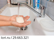 Ребенок держит в руках мыло, на которое течет вода из смесителя. Стоковое фото, фотограф Иванов Алексей / Фотобанк Лори