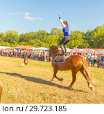 Russia, Samara, July, 2018: a Cossack girl rides a horse and performs tricks. Редакционное фото, фотограф Акиньшин Владимир / Фотобанк Лори