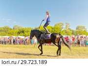Russia, Samara, July, 2018: a Cossack girl rides a horse and performs tricks. Редакционное фото, фотограф Акиньшин Владимир / Фотобанк Лори
