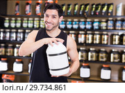Positive attractive sportman demostration sport nutrition in shop. Стоковое фото, фотограф Яков Филимонов / Фотобанк Лори