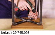Worker fastens the screws with the screwdriver in the stool closeup. Стоковое видео, видеограф Алексей Кузнецов / Фотобанк Лори