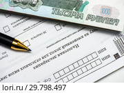 Оплата налогов. Пачка бумажных банкнот, авторучка и незаполненный бланк налоговой декларация на вменённый доход. Стоковое фото, фотограф Игорь Низов / Фотобанк Лори