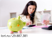 Young woman with receipts in budget planning concept. Стоковое фото, фотограф Elnur / Фотобанк Лори