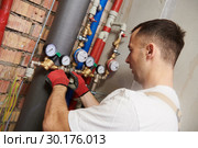 plumber installing and mounting water equipment - meter, filter and pressure reducer. Стоковое фото, фотограф Дмитрий Калиновский / Фотобанк Лори