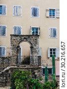 The facade of an ordinary old building with a door and windows in Montenegro. Traditional housing. Стоковое фото, фотограф Николай Коржов / Фотобанк Лори