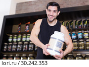 Attractive athletic man seller demostration sport nutrition. Стоковое фото, фотограф Яков Филимонов / Фотобанк Лори
