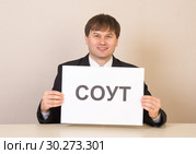 Сотрудник с табличкой СОУТ за столом в офисе. Стоковое фото, фотограф Гетманец Инна / Фотобанк Лори